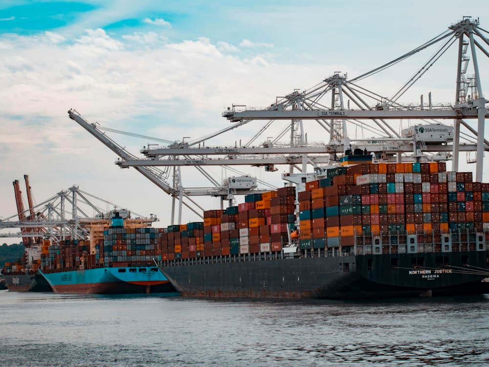 Cranes and container ships alongside a busy port terminal.